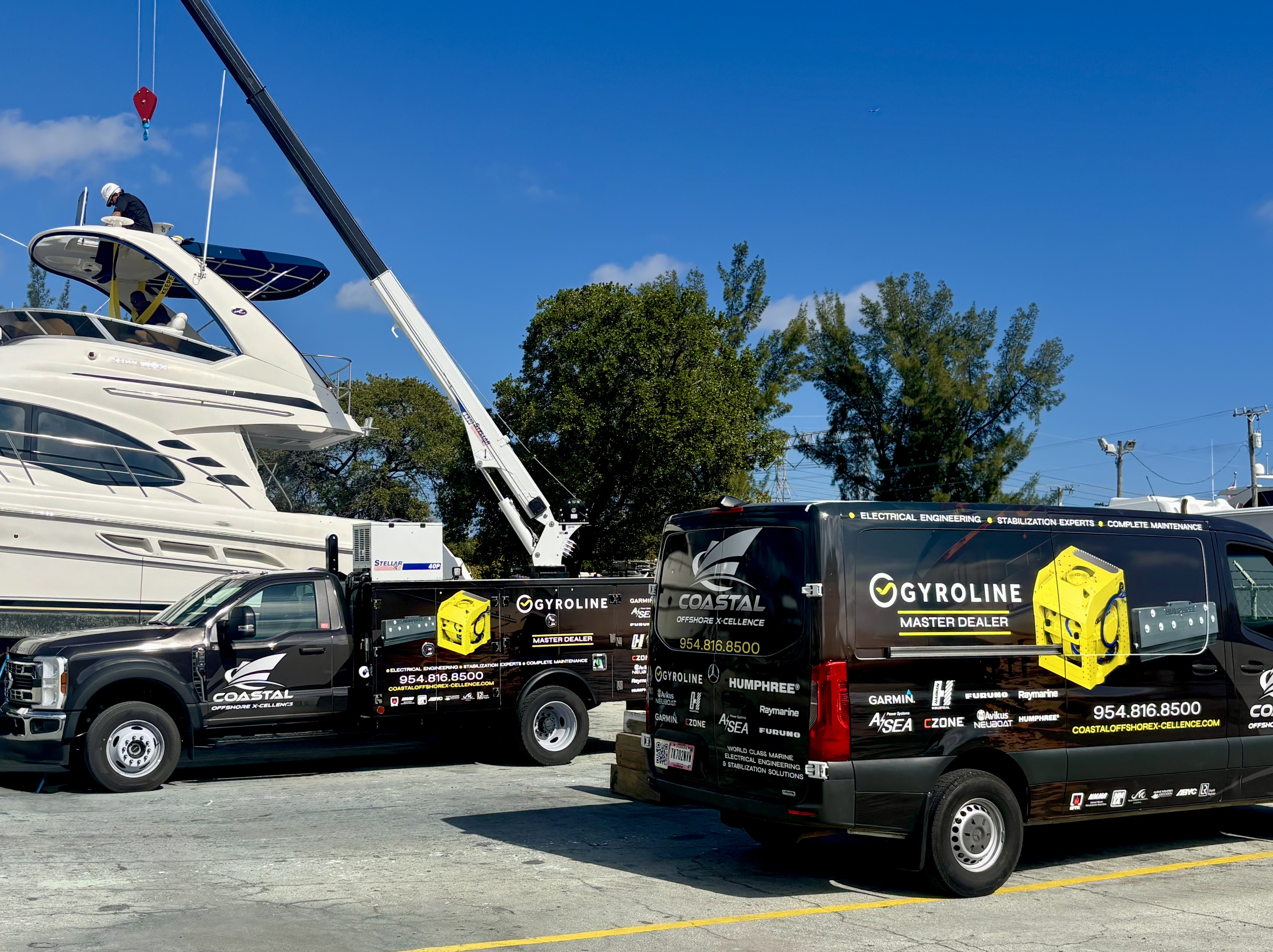 Coastal service vehicles beside a yacht during an installation in Fort Lauderdale